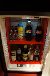 a mini fridge full of soda bottles and other beverages