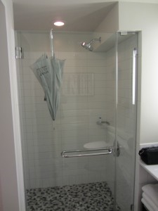 a glass shower with a white tile floor