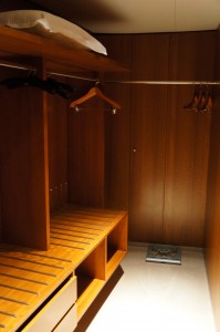 a wooden closet with a shelf and swingers