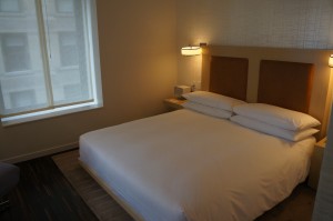 a bed with white sheets and a lamp