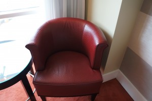 a red leather chair in a corner of a room