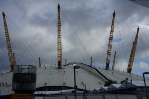 a large dome with towers with The O2 Arena in the background