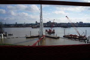 a view of a body of water with cranes and a tower