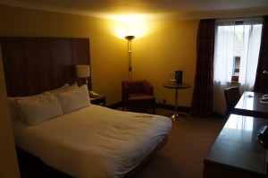 a hotel room with a bed and a lamp