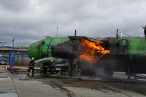 a firefighter spraying water on a green machine