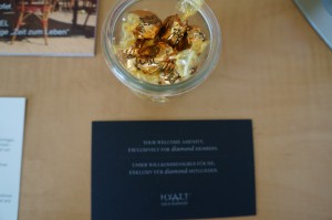 a glass jar with gold foil wrapped candy in it next to a black card