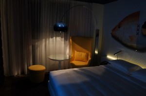 a bed with a lamp and a chair