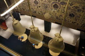 a group of bells from a glass case