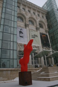 a red statue in front of a building