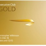 a business card with a gold ribbon