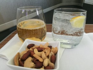 a bowl of nuts and a glass of liquid next to a glass of liquid