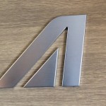 a metal letter on a wood surface