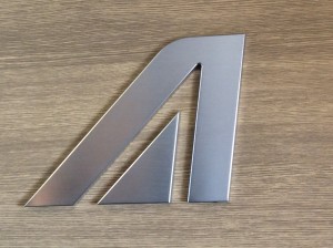 a metal letter on a wood surface