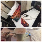 a bed with a cup of coffee and headphones