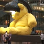 a large yellow stuffed animal statue in a building