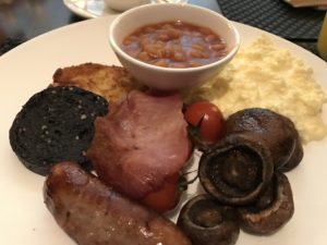 a plate of food with a bowl of beans and sausage