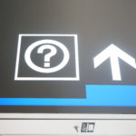 a sign with a question mark and arrow